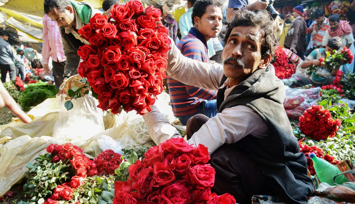 Aktivitas pedangang bunga mawar di pasar bunga grosir di Kolkata, India (7/2). Jelang perayaan hari Valentine, bunga mawar banyak diburu dari tanggal 7 Februari dengan ditandai dengan Rose Day. (AFP Photo/Dibyangshu Sarkar)