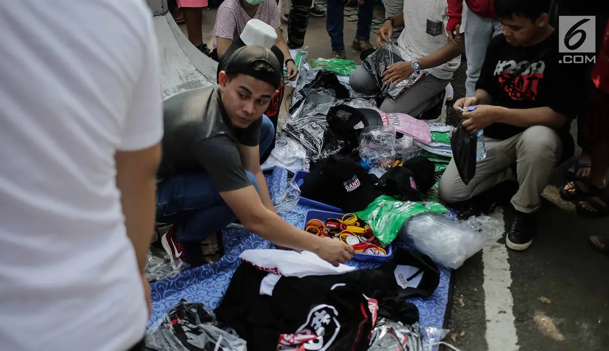 Pedagang menggelar dagangannya berupa atribut dan kaus #2019GantiPresiden saat Car Free Day di Bundaran HI, Jakarta, Minggu (29/4). Pedagang banyak meraup untung dari penjualan kaus dan atribut bertagar #2019GantiPresiden. (Liputan6.com/Faizal Fanani)