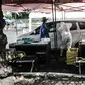 Petugas kesehatan melakukan tes usap PCR drive thru kepada pengguna kendaraan di halaman Rumah Sakit Pertamina Jakarta (RSPJ), Rabu (6/1/2021). RSPJ menyediakan layanan tes usap PCR mandiri secara drive thru guna melacak sekaligus memutus penyebaran Covid-19. (merdeka.com/Iqbal Nugroho)