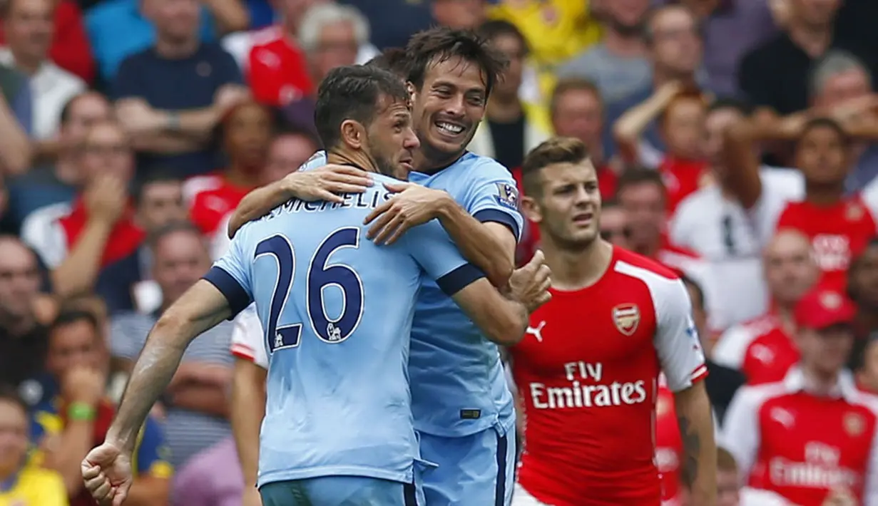 Pemain Manchester City, Martin Demichelis (kiri) dan David Silva, merayakan hasil imbang 2-2 kala melawan Arsenal di Stadion Emirates, London, (13/9/2014). (REUTERS/Eddie Keogh)