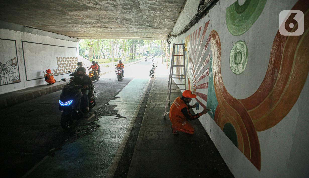 Petugas Penanganan Prasarana dan Sarana Umum (PPSU) menyelesaikan lukisan mural pada tembok kolong Semanggi, Jakarta, Jumat (7/7/2023). Pembuatan mural tersebut guna mempercantik kawasan tersebut yang selalu dilewati pengguna jalan. (Liputan6.com/Faizal Fanani)