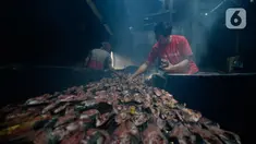 Pekerja menyusun ikan lele yang diasapin (panggang) selama dua hari di Kelurahan Pengasinan, Kecamatan Gunung Sindur, Kabupaten Bogor, Jawa Barat, Jumat (11/09/2020). (merdeka.com/Dwi Narwoko)