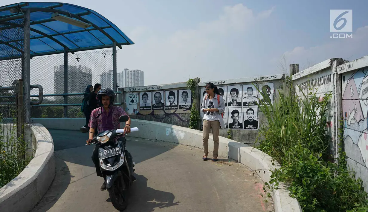Pengendara sepeda motor dan pejalan kaki melewati poster 13 aktivis yang hilang di kawasan Beji, Depok, Jawa Barat, Selasa (18/6/2019). Poster itu mengingatkan masyarakat masih ada pekerjaan rumah pemerintah berupa pelanggaran HAM berat yang belum tuntas hingga kini. (Liputan6.com/Immanuel Antonius)