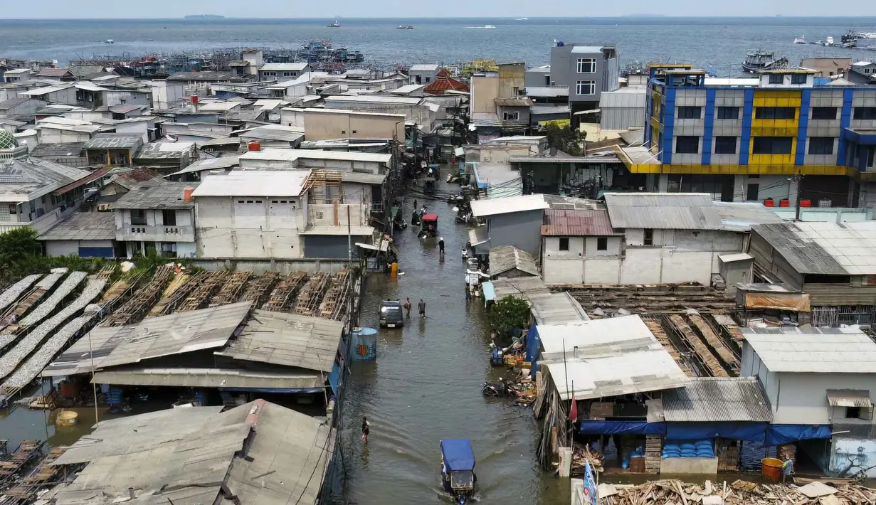 Warga diimbau untuk tetap waspada karena banjir rob diperkirakan masih berpotensi terjadi hingga 7 Desember 2025, dengan prediksi puncak pasang terjadi setiap hari pada pagi hingga siang hari. Tampak foto udara menunjukkan permukiman yang terendam air pasang di Muara Baru, Jakarta, pada Sabtu 6 Desember 2025. (ADITYA IRAWAN/AFP)