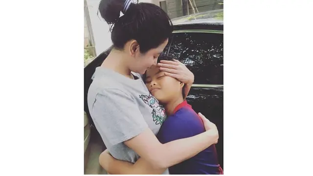 Saat bersama dengan sang anak Dewi Perssik terlihat simple dengan memakai kaos dan menguncir rambut.