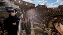 Wisatawan mengunjungi Colosseum di Roma, Sabtu (7/3/2020). Kekhwatiran terhadap virus corona (COVID-19) membuat tempat-tempat pariwisata di Italia sepi pengunjung, seperti di kawasan Colosseum yang merupakan salah satu dari keajaiban dunia. (AP Photo/Andrew Medichini)