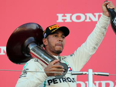 Pembalap Mercedes, Lewis Hamilton mengangkat trofi setelah memenangi Formula Satu (F1) Grand Pix Jepang di Sirkuit Suzuka, Jepang (7/10). Dengan kemenangan ini, Hamilton unggul 67 poin atas pesaing terdekatnya, Sebastian Vettel. (AP Photo/Ng Han Guan)