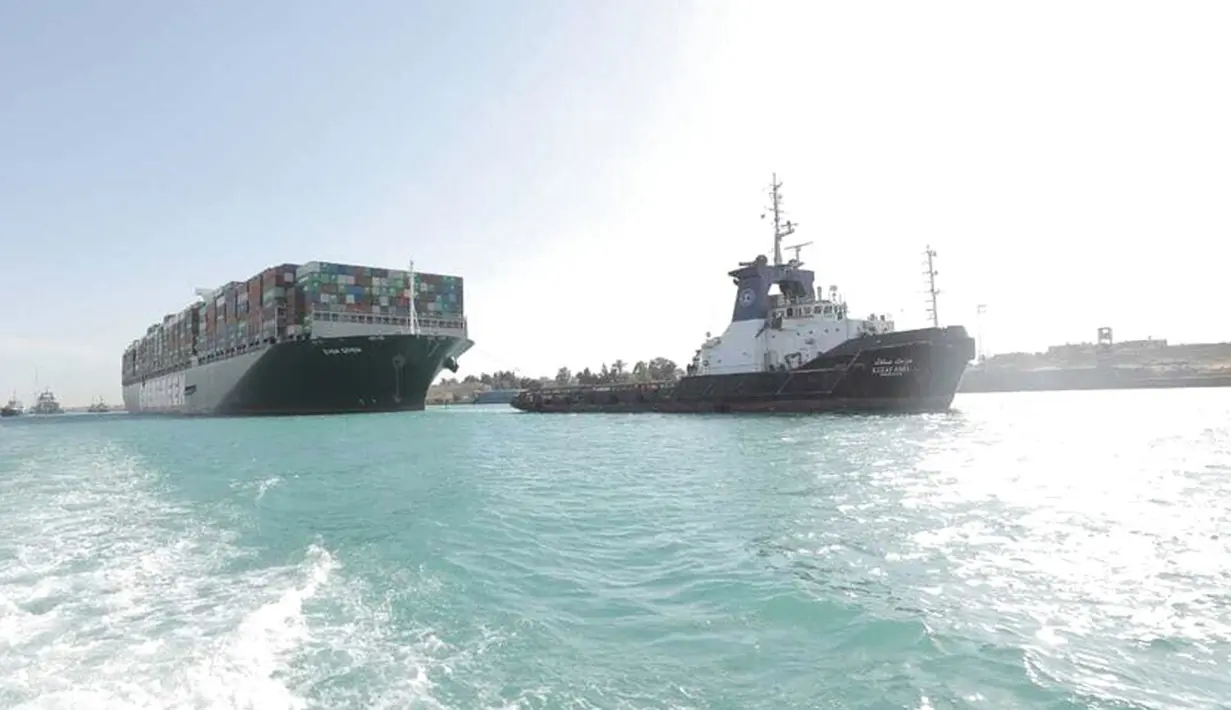 Kapal kargo Ever Given ditemani kapal tunda saat melaju di Terusan Suez, Mesir, Senin (29/3/2021). Peter Berdowski, CEO dari perusahaan penyelamatan Belanda Boskalis, mengatakan Ever Given telah diapungkan kembali. (Suez Canal Authority via AP)