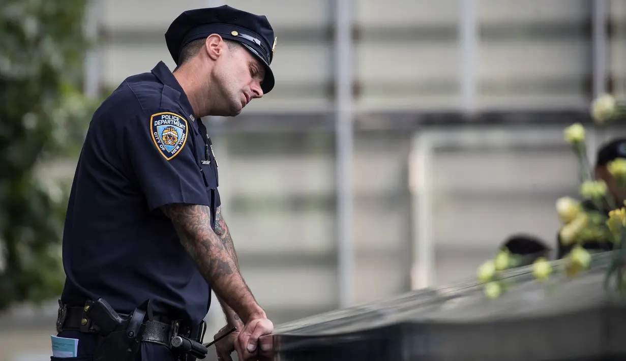 Ekspresi petugas New York City Police Department (NYPD) selama peringatan 16 tahun korban serangan 11 September di Museum dan Memorial Nasional 9/11, New York, Amerika Serikat, Senin (11/9). (Drew Angerer/Getty Images/AFP)