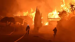 Petugas memadamkan api di sebuah rumah di Ventura, California, AS (5/12). Sekitar penghuni 7.786 rumah di Ventura dan Santa Paula mendapat mandat evakuasi wajib dari dinas pemadam kebakaran lokal. (Ryan Cullom / Ventura County Fire Department via AP)