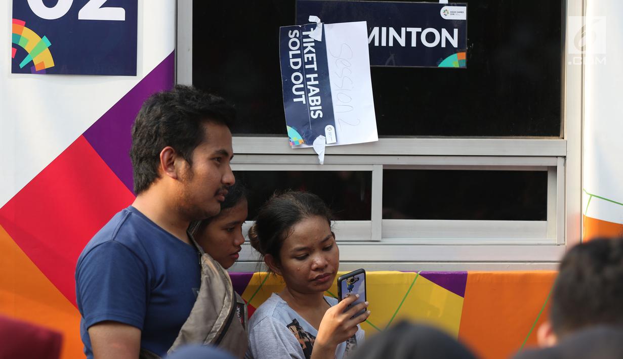 Calon penonton antre untuk mendapatkan tiket final bulu tangkis beregu putra di sekitar tiket boks di kawasan GBK, Jakarta, Rabu (22/8). Laga final bulu tangkis beregu putra mempertemukan Indonesia melawan China. (Liputan6.com/Helmi Fithriansyah)