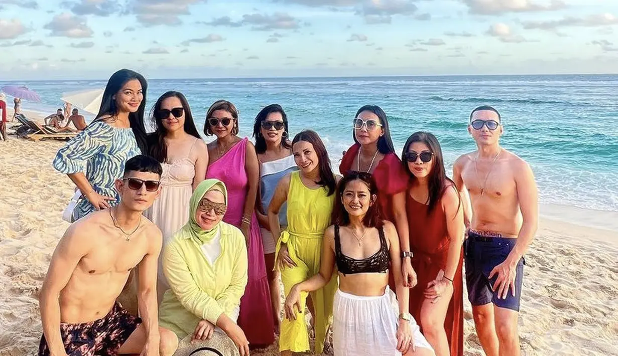 Saat berada di pantai, ibu dua anak ini memilih mengenakan mini dress off shoulder warna biru bercorak. Rambut panjangnya dibiarkan tergerai.  (@titi_kamall)