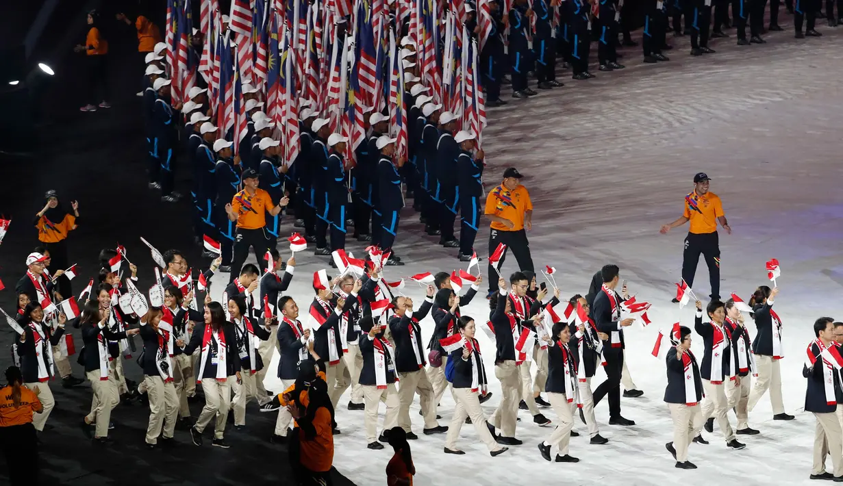 Kontingen Indonesia mengibarkan bendera Merah Putih ketika mengikuti devile pembukaan SEA Games XXIX di Stadion Bukit Jalil, Kuala Lumpur, Sabtu (19/8). Pembukaan SEA Games ke-29 tercoreng dengan gambar bendera Indonesia terbalik. (AP Photo/Vincent Thian)