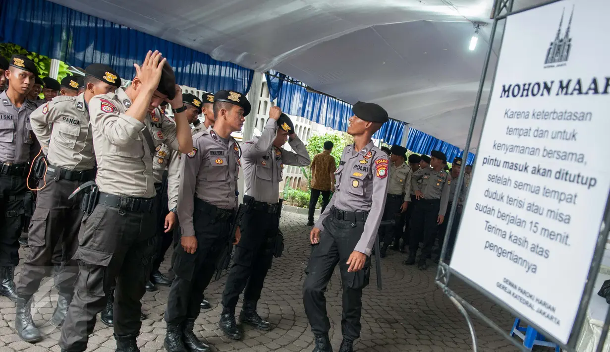 Sejumlah petugas berjaga di Gereja Katedral, Jakarta, Kamis (13/4). Sterilisasi ini untuk memberikan rasa aman kepada umat Katolik yang melaksanakan rangkaian misa Tri Hari Suci Paskah. (Liputan6.com/Gempur M Surya)