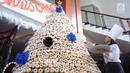 Karyawan menghiasi pohon Natal yang terbuat dari susunan donat di lobby hotel Dafam Semarang, Rabu (12/12). Pohon Natal setinggi 3 meter untuk menyambut Natal tersebut terdapat 2000 buah kue donat. (Liputan6.com/Gholib)