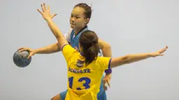Pebola tangan putri Indonesia, Gadis Risma, berusaha melewati hadangan pebola tangan putri Filipina, Dana Lora Schulte pada International Handball Federation Trophy 2016 di Jakarta, Sabtu (5/3/2016). (Bola.com/Vitalis Yogi Trisna)