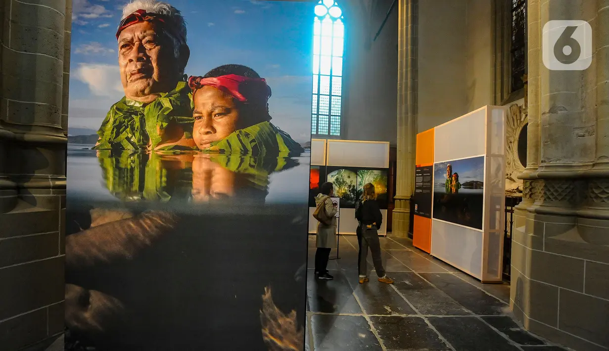 Pengunjung mengamati karya foto pemenang World Press Photo (WPP) 2024 di De Nieuwe Kerk Amsterdam, Belanda, Rabu (22/5/2024). (merdeka.com/Arie Basuki)