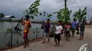 Sejumlah bocah membawa tanaman mangrove untuk ditanam di Desa Muara Ujung, Tangerang, Banten, Minggu (7/12/2014). (Liputan6.com/Johan Tallo) 