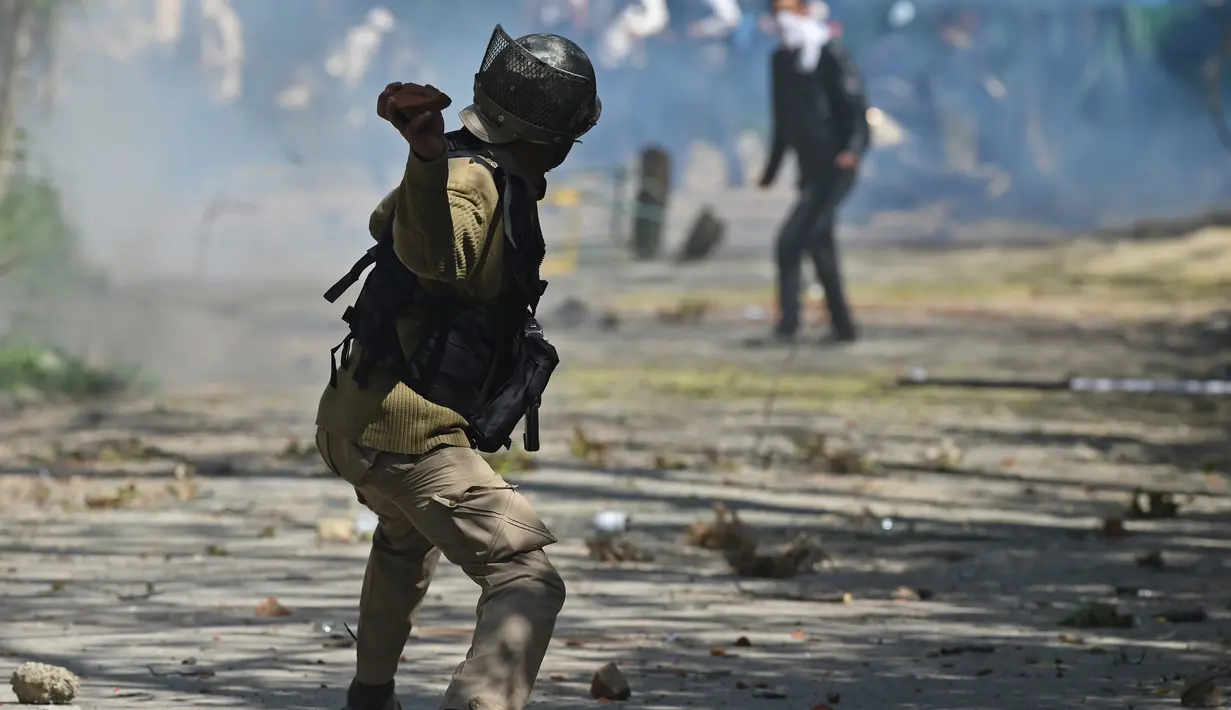 Saling lempar terjadi saat bentrok antara mahasiswa dan polisi di Srinagar, Kashmir, India,  Senin (17/4). Aksi Mahasiswa tersebut untuk memprotes razia polisi di sebuah perguruan tinggi. (AFP Photo / TAUSEEF MUSTAFA)
