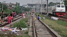 Anak-anak bermain layang-layang di rel kereta api kawasan Jakarta Timur, Kamis (3/1). Rel yang sering dilintasi kereta api tersebut sangat membahayakan diri mereka. (Merdeka.com/Iqbal Nugroho)