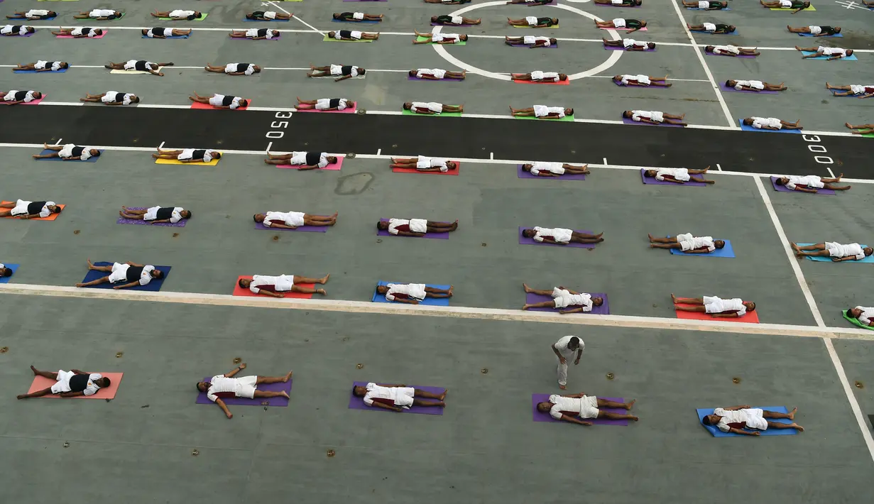 Sejumlah Personel Angkatan Laut India melakukan gaya yoga di atas kapal induk INS Viraat pada Hari Yoga Internasional di atas kapal induk INS Viraat di pelabuhan Mumbai, India, (21/6). (AFP Photo/Punit Paranjpe)