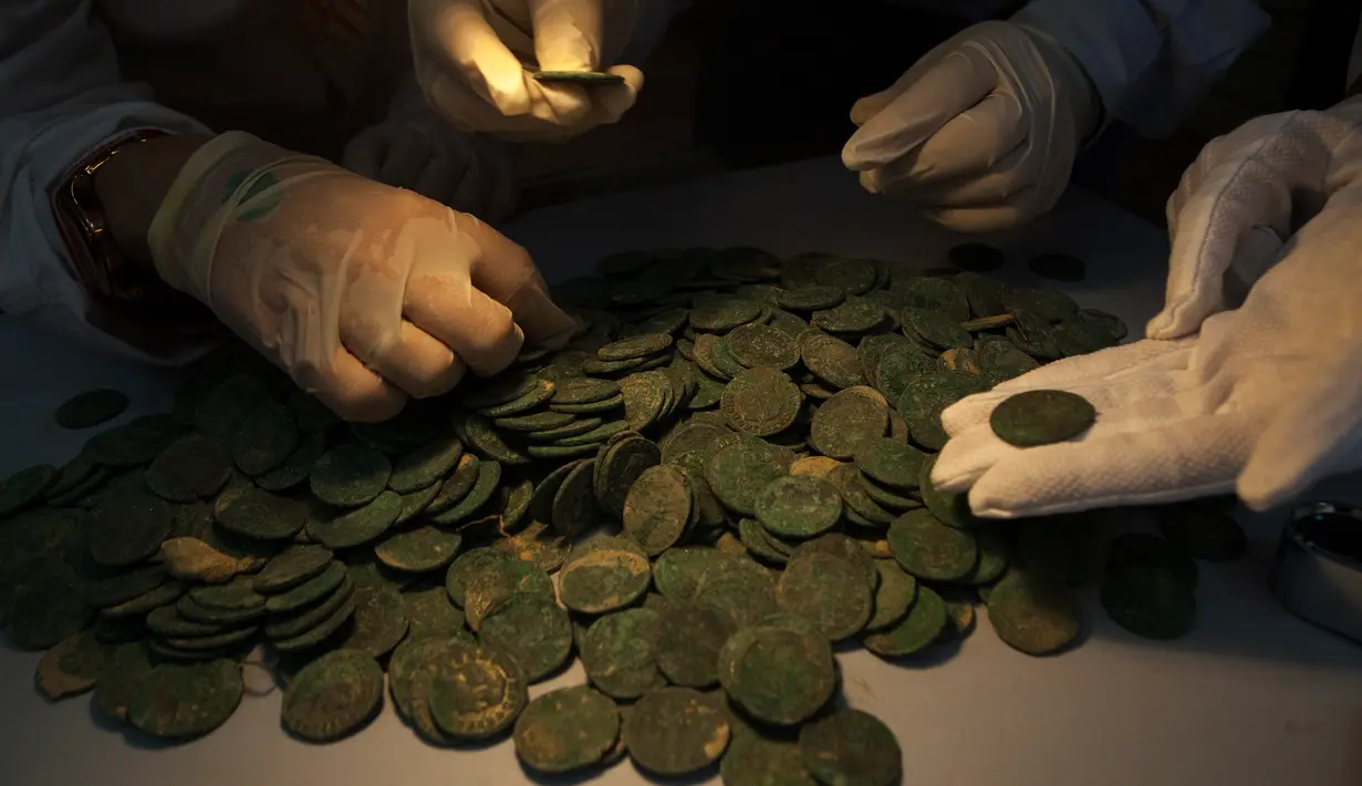 Koin kuno Romawi diperlihatkan di museum arkeologi di Sevilla, Kamis (28/4). Koin kuno yang memiliki bobot total sebanyak 600 kg itu ditemukan ketika para pekerja konstruksi  sedang mengerjakan proyek pipa air di Spanyol Selatan. (Gogo Lobato/AFP)