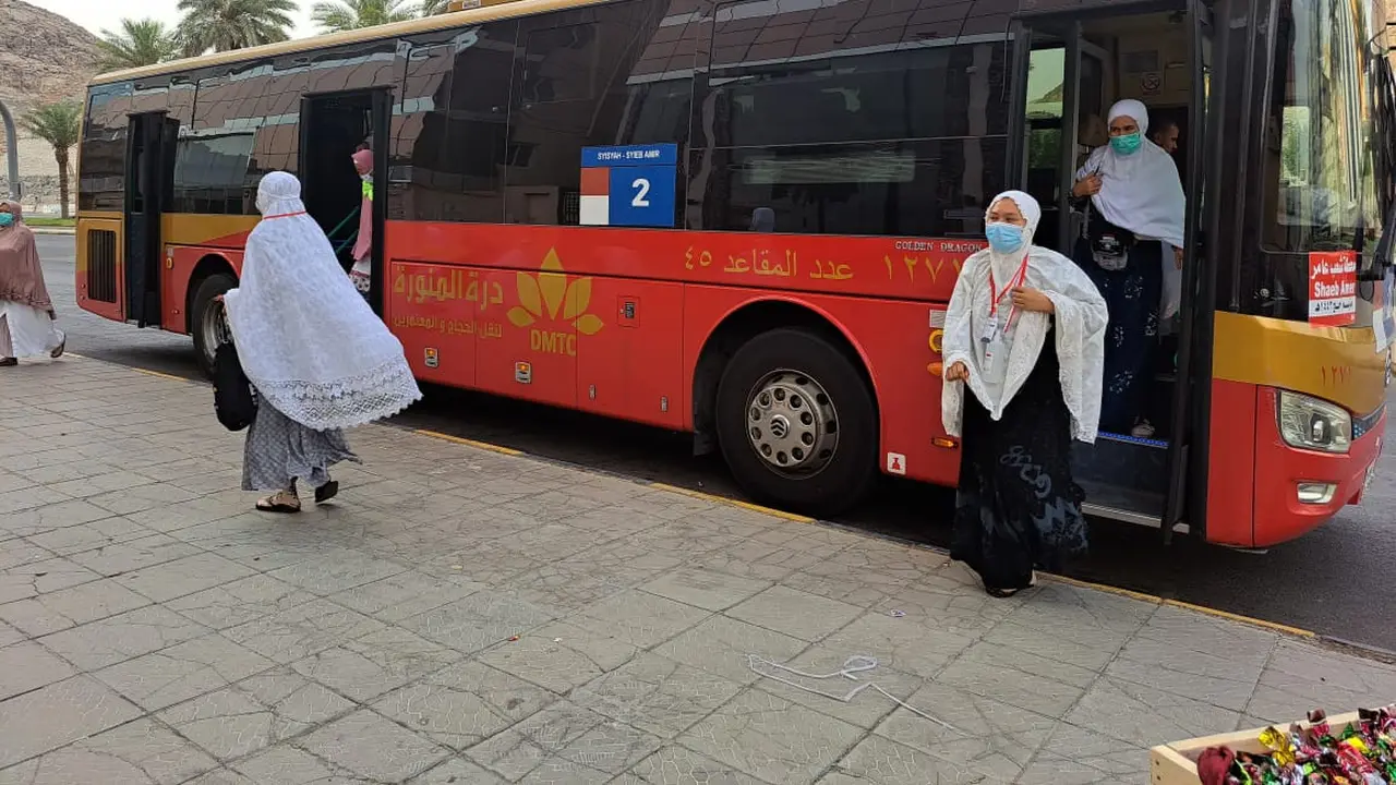 Jemaah calon haji turun dari bus shalawat, Sabtu (25/6/2022). (Liputan6.com/ Mevi Linawati)