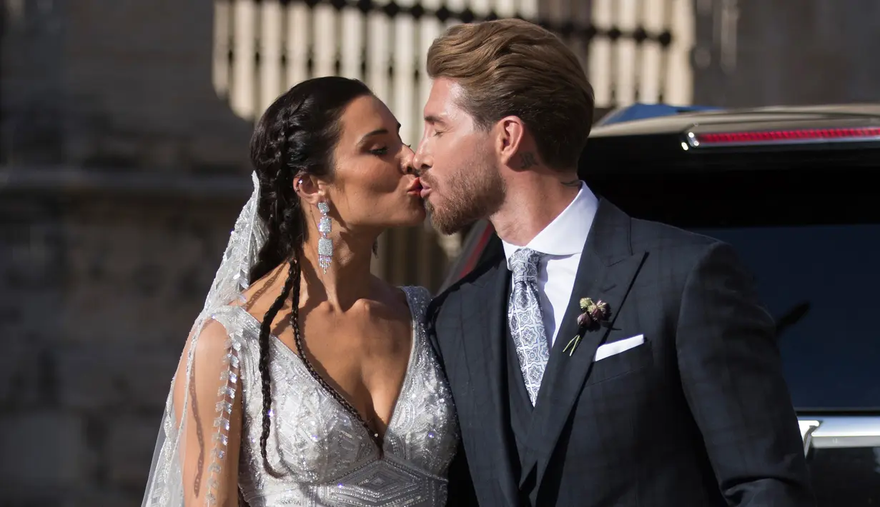 Bek Real Madrid, Sergio Ramos mencium istrinya Pilar Rubio setelah upacara pernikahan mereka di Sevilla, Spanyol (15/6/2019). Sergio Ramos dan Pilar Rubio telah memiliki tiga putra yaitu, Sergio, Marcos, dan Alejandro. (AP Photo/Antonio Pizarro)