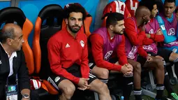 Penyerang Mesir, Mohamed Salah berada di bangku cadangan selama pertandingan grup A Piala Dunia 2018 melawan Uruguay di Yekaterinburg Arena di Yekaterinburg, Rusia, (15/6). Uruguay menang dramatis atas Mesir 1-0. (AP Photo / Mark Baker)