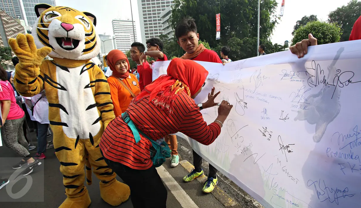 Warga memberikan tanda tangan dalam kampanye bertajuk 'Ayo Hentikan Kejahatan Lingkungan dan Kehutanan' di Jakarta, (20/12). Aplikasi ini bertujuan mengajak masyarakat aktif dalam memberikan laporan kejahatan lingkungan. (Liputan6.com/Immanuel Antonius)