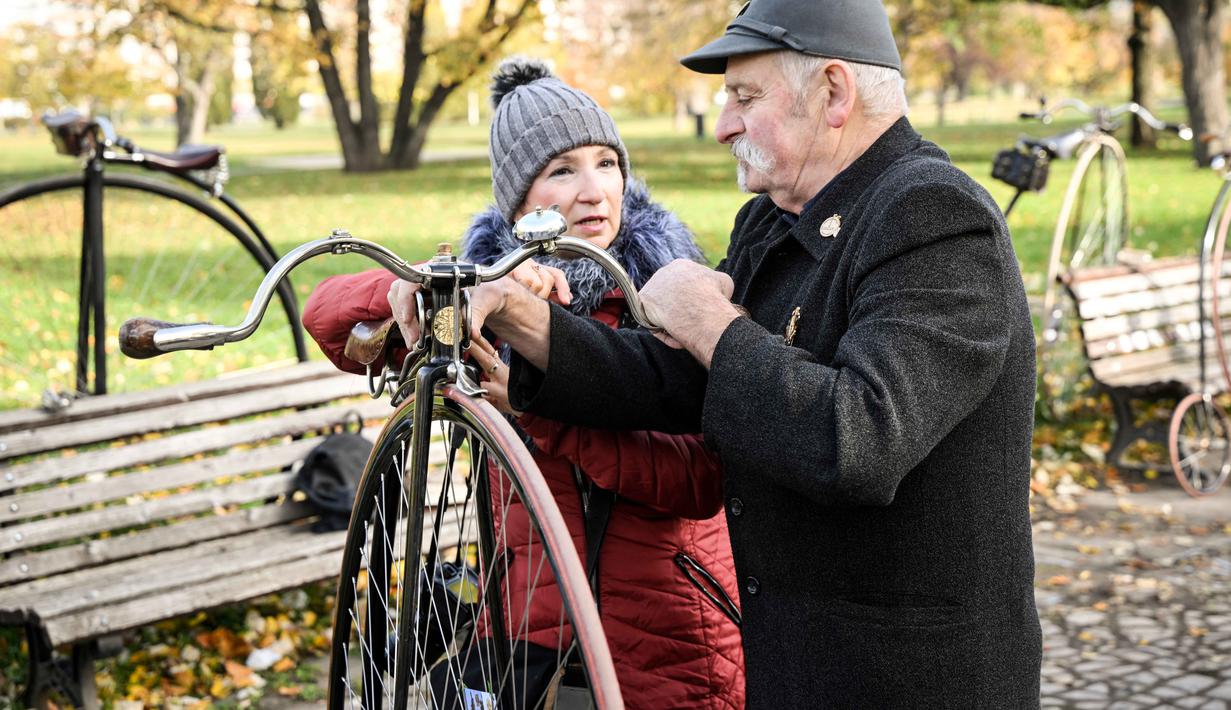 Para penggemar sepeda yang mereka sebut penny-farthing, atau yang juga dikenal sebagai high wheel, dalam kompetisi tradisional 'One Mile Race' di Taman Letna, Praha, Republik Ceko, pada 1 November 2025. Jenis sepeda Penny Farthing cukup tinggi dan unik, karena memiliki dua roda yang masing-masing berukuran besar dan kecil dengan pedal yang dipasang langsung pada poros roda. (Michal Cizek/AFP)