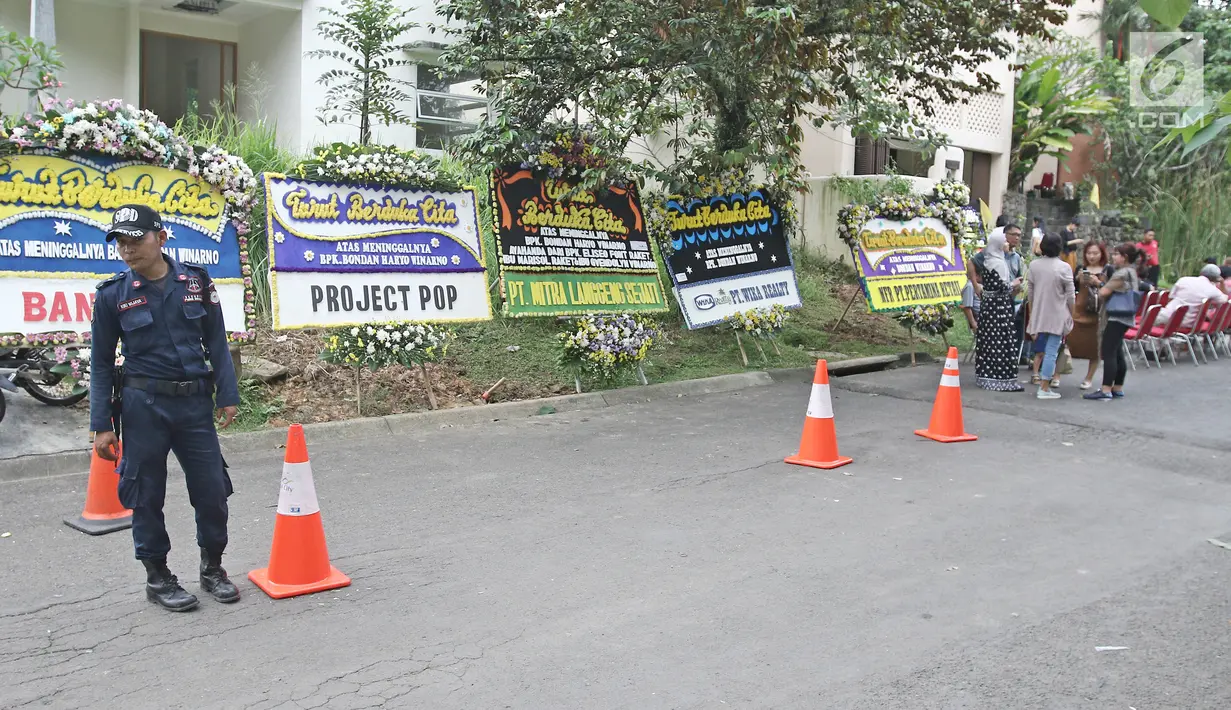 Seorang petugas keamanan berjaga di dekat rumah duka pakar kuliner Bondan Winarno di Perumahan Sentul City, Bogor, Rabu (29/11). Setiap tamu yang hendak masuk ke cluster itu pun tak luput dari pemeriksaan petugas keamanan. (Liputan6.com/Herman Zakharia)