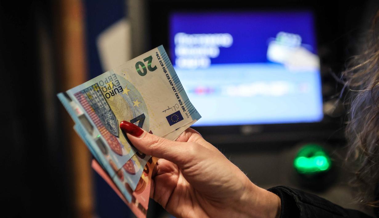 Penerapan euro akan dilakukan secara bertahap. Sepanjang Januari 2026, masyarakat Bulgaria masih diperbolehkan menggunakan dua mata uang secara bersamaan, Lev Bulgaria tetap berlaku berdampingan dengan euro selama masa transisi tersebut. Tampak dalam foto, seseorang menunjukkan uang kertas euro yang ditarik dari ATM di Sofia, Bulgaria, Kamis 1 Januari 2026, saat negara tersebut bergabung dengan serikat mata uang euro. (AP Photo/Valentina Petrova)