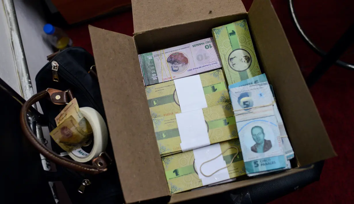 Sejumlah uang lokal ditumpuk didalam kardus di Caracas, Venezuela (15/12). Mata uang lokal yang bernama Panal ini diluncurkan di lingkungan kelas pekerja "23 de Enero". (AFP Photo/Federico Parra)