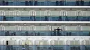 Penumpang berdiri di balkon kapal pesiar Diamond Princess di Daikoku Pier Cruise Terminal di Yokohama (7/2/2020). Ribuan penumpang terpaksa harus dikarantina setelah seorang penumpang yang turun di Hong Kong pada Januari lalu dinyatakan positif terinfeksi Corona. (AP Photo/Eugene Hoshiko)