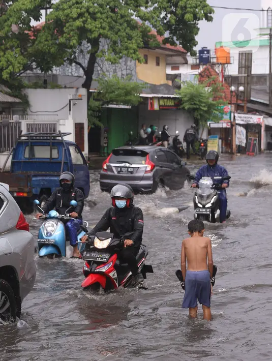 Pengendara terjebak banjir yang menggenangi jalan Bayangkara Pusdiklat, Kota Tangerang Selatan, Banten, Selasa (2/11/2021). BMKG mengeluarkan peringatan potensi cuaca ekstrem di wilayah Jakarta, Bogor, Depok, Tangerang, dan Bekasi (Jabodetabek). (Liputan6.com/Angga Yuniar)