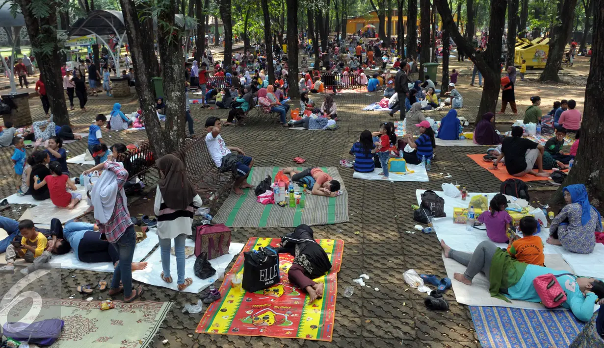 Sebagian pengunjung berkumpul di bawah rimbun pepohonan, Ragunan, Jakarta, Jumat (6/5). Mereka menggelar tikar seraya menikmati bekal makanan yang mereka bawa. (Liputan6.com/Helmi Afandi)