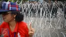 Pendukung Cagub DKI Basuki T Purnama memberikan salam dua jari saat sidang kasus penistaan agama, Jakarta, Selasa (10/1). Dengan mengenakan atribut kotak-kotak, massa membawa bendera Indonesia serta melakukan orasi damai. (Liputan6.com/Immanuel Antonius)