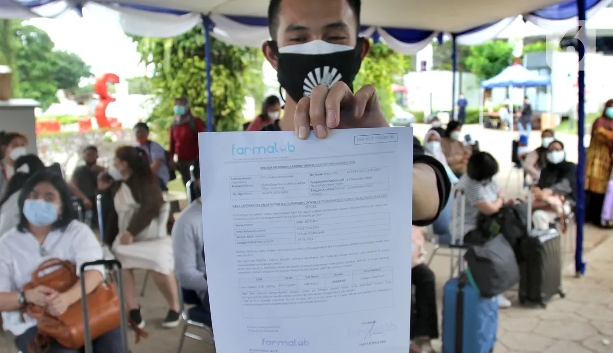 Calon penumpang menunjukkan hasil rapid test antigen di Terminal 2 Bandara Soekarno-Hatta, Tangerang, Banten, Selasa (22/12/2020). Layanan rapid test antigen dibanderol dengan harga Rp 200 ribu. (merdeka.com/Arie Basuki)