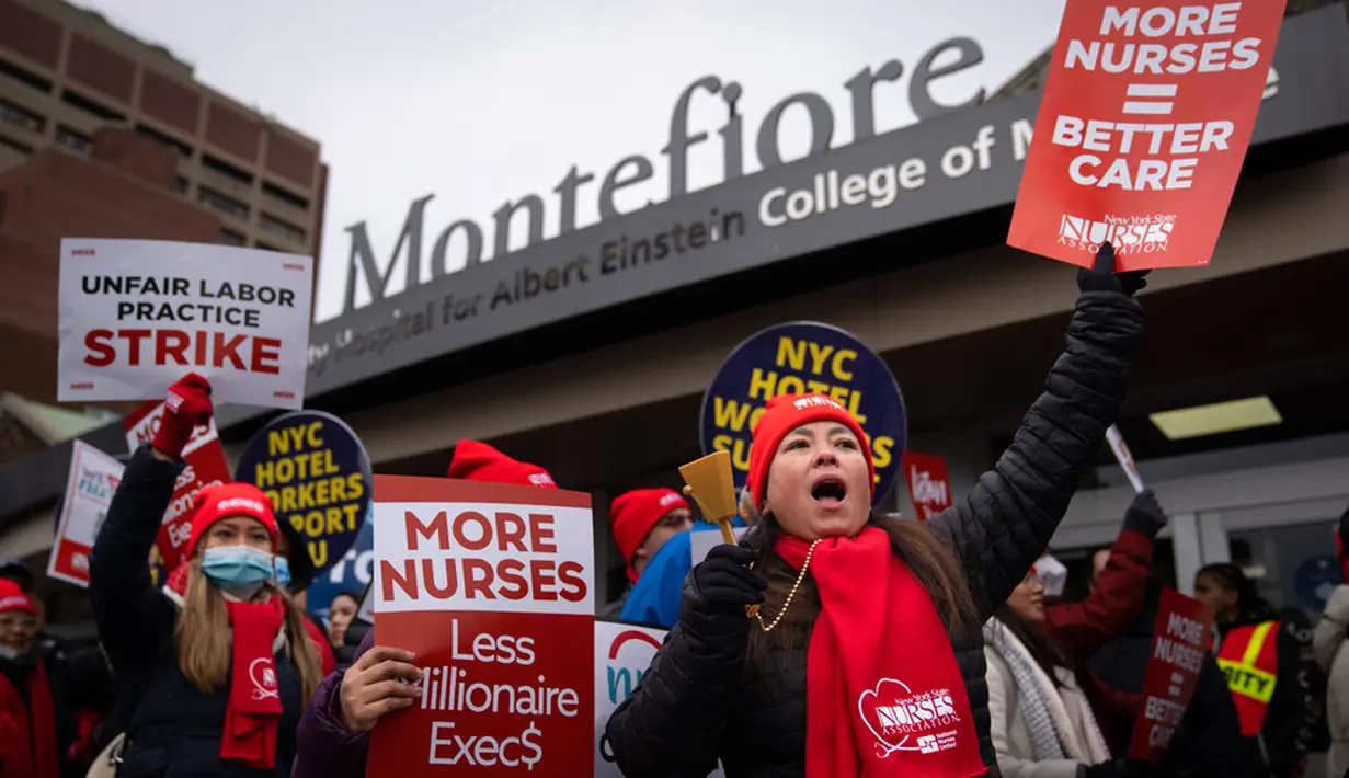 Para pengunjuk rasa berbaris saat melakukan aksi mogok kerja di jalan sekitar Montefiore Medical Center, Bronx, New York, Amerika Serikat, 11 Januari 2023. Mereka membawa spanduk tuntutan meminta rumah sakit mempekerjakan lebih banyak perawat dan menaikkan upah. (AP Photo/John Minchillo)