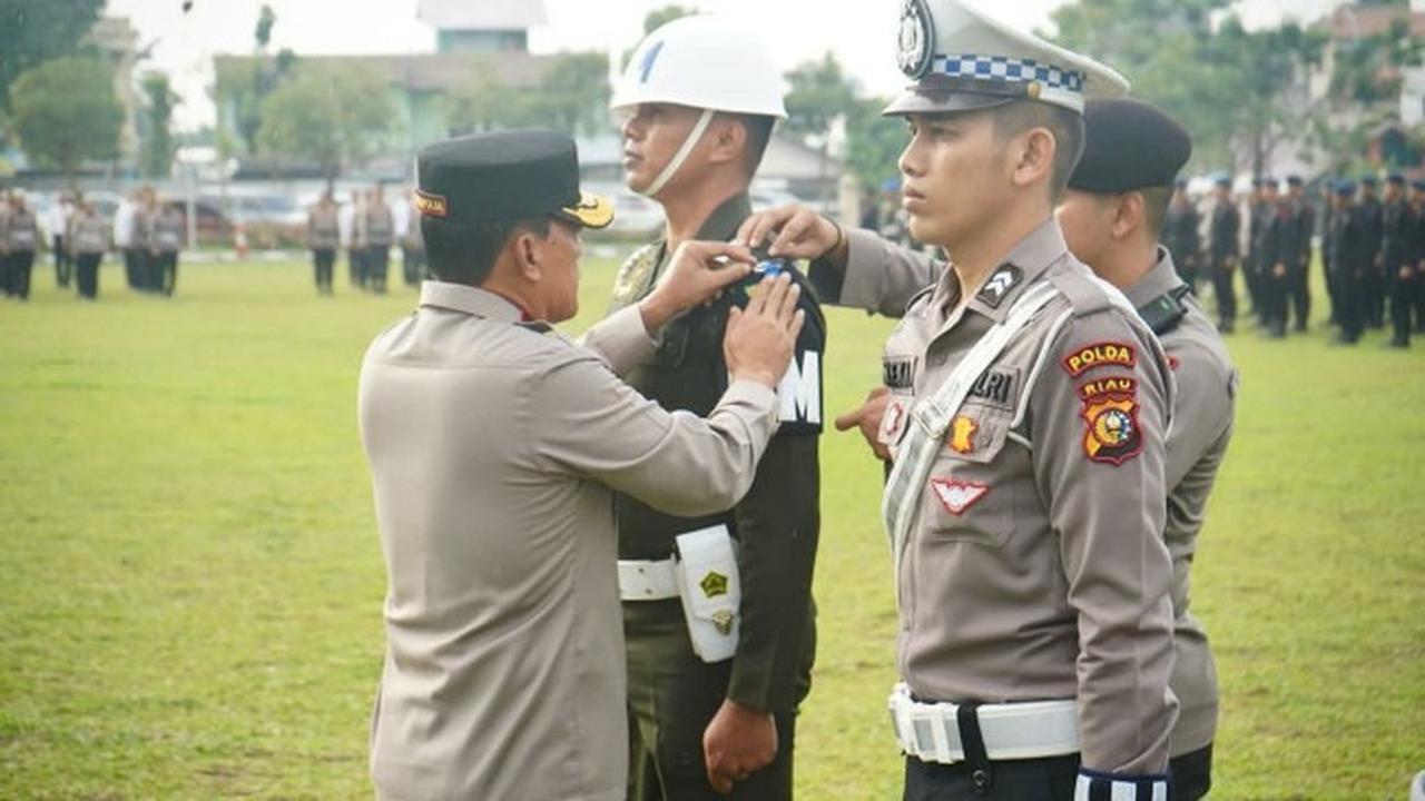 Wakil Kepala Polda Riau Brigjen Kasihan Rahmadi memasang pita kepada petugas yang melaksanakan Operasi Patuh 2023.