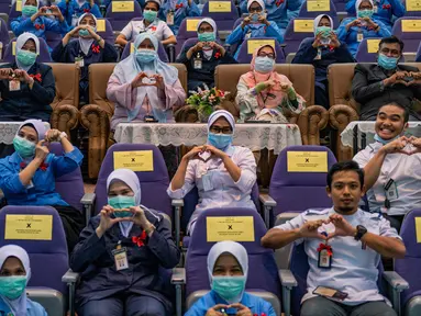 Para perawat membuat simbol cinta saat peringatan Hari Perawat Internasional di Rumah Sakit Selayang, Selayang, Malaysia, Selasa (12/5/2020). Hari Perawat Internasional tahun ini diperingati di tengah pandemi virus corona COVID-19. (Mohd RASFAN/AFP)