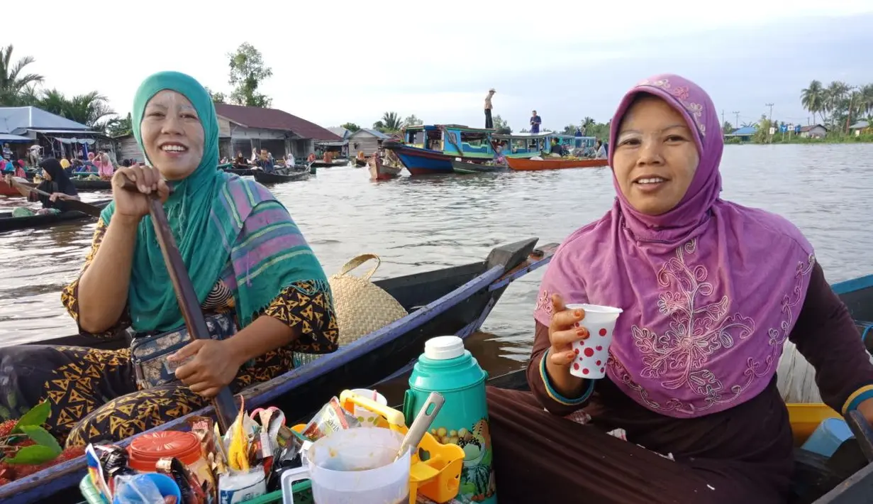 Para pedangan Pasar Terapung Lok Baintan memakai bedak dingin pada wajahnya untuk menangkal cahaya panas matahari yang juga menjadi budaya di Banjarmasin (Liputan6.com/Pool/Kadek Arini)