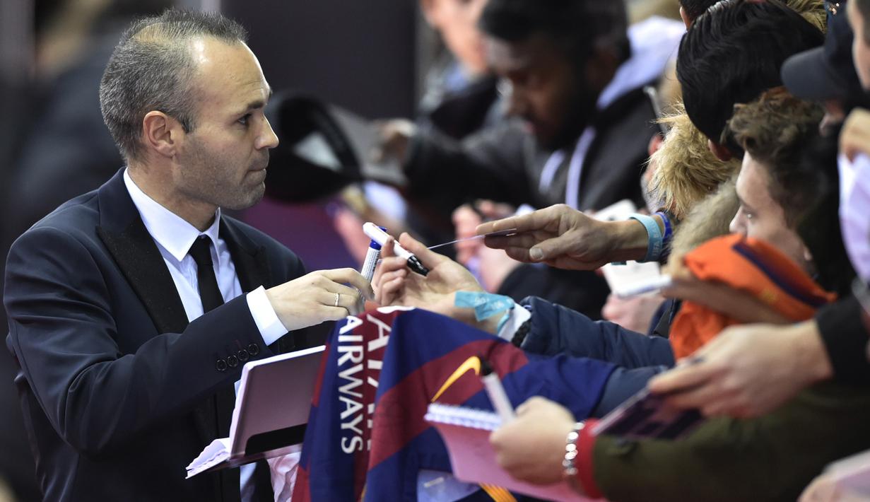 Gelandang Barcelona, Andres Iniesta, memberikan tanda tangan saat menghadiri malam penghargaan Ballon d'Or di Zurich, Senin (11/1/2016). Pada 2016 dirinya juga sempat menjadi tiga nominasi peraih Ballon d'Or. (AFP/Michael Buholzer)
