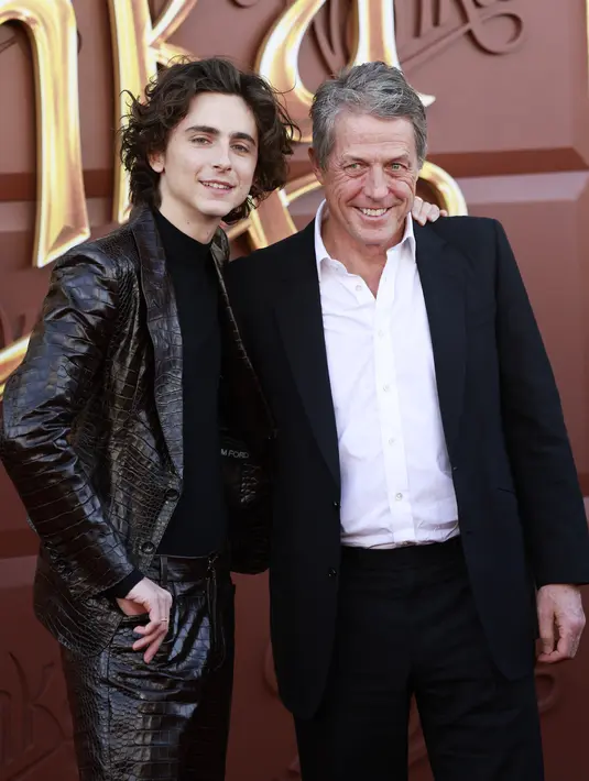 Chalamet melemparkan senyum lebarnya di samping Hugh Grant, yang memerankan Lofty si Oompa-Loompa. (JC Olivera / GETTY IMAGES NORTH AMERICA / Getty Images via AFP)
