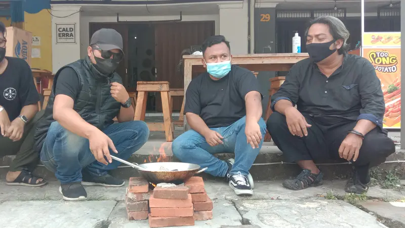 Pedagang dan Pemilik Kafe Memasak Batu Karena PPKM Diperpanjang. (Selasa, 03/08/2021). (Liputan6.com/Yandhi Deslatama).