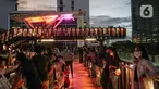 Warga berada di balkon Jembatan Penyeberangan Orang dan Sepeda (JPOS Phinisi) di kawasan Karet, Jakarta, Minggu (20/3/2022). JPOS Phinisi kini menjadi objek baru bagi warga Jakarta. (Liputan6.com/Faizal Fanani)