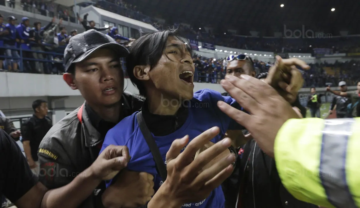 Petugas berusaha menghalangi bobotoh yang menghampiri pemain Persib pada laga Piala Presiden di Stadion GBLA, Bandung, Jumat (26/1/2018). Persib tersingkir dari Piala Presiden 2018 setelah takluk 0-1 dari PSM. (Bola.com/M Iqbal Ichsan)