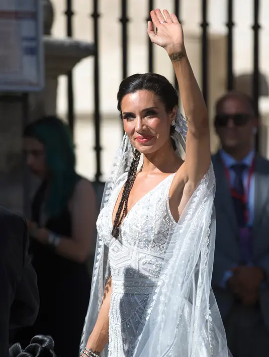 Model dan presenter Pilar Rubio menyapa awak media saat tiba di gereja dalam upacara pernikahannya di Katedral Seville, Spanyol (15/6/2019). Sergio Ramos dan Pilar Rubio telah memiliki tiga putra yaitu, Sergio, Marcos, dan Alejandro. (AP Photo/Antonio Pizarro)