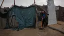 Warga pengungsi harus berjuang untuk tetap kering dan hangat di tengah kondisi yang memburuk. Tampak dalam foto, Hosni Abu Reda membersihkan air dari tendanya di sebuah kamp pengungsi Palestina setelah hujan deras di Khan Younis, Jalur Gaza selatan, Kamis 11 Desember 2025. (AP Photo/Abdel Kareem Hana)